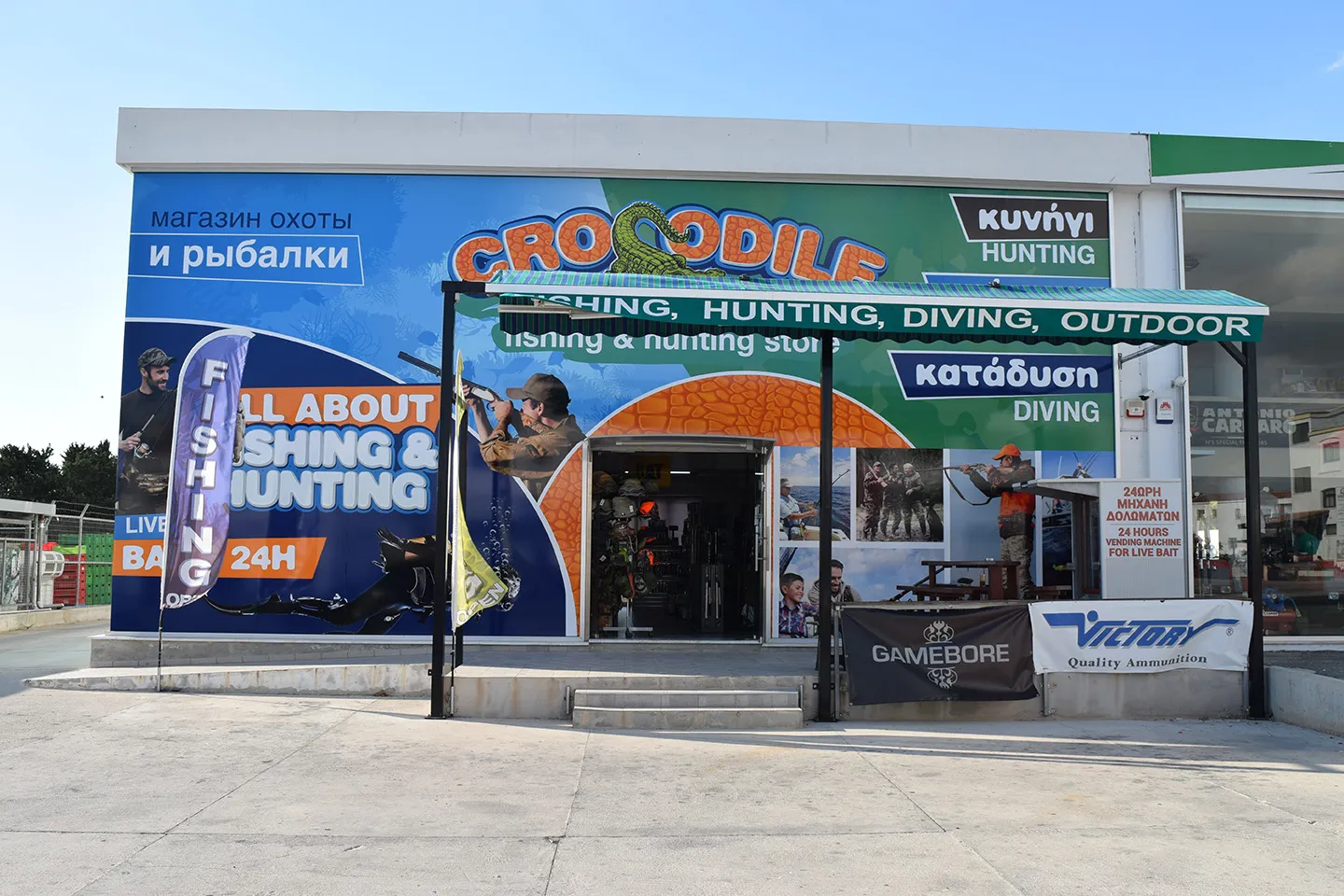 CROCODILE fishing and hunting store front on Mesogi Avenue, signs for hunting, fishing and diving