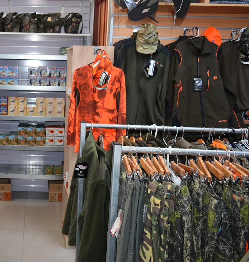 Hunting jackets in green and orange on the rails